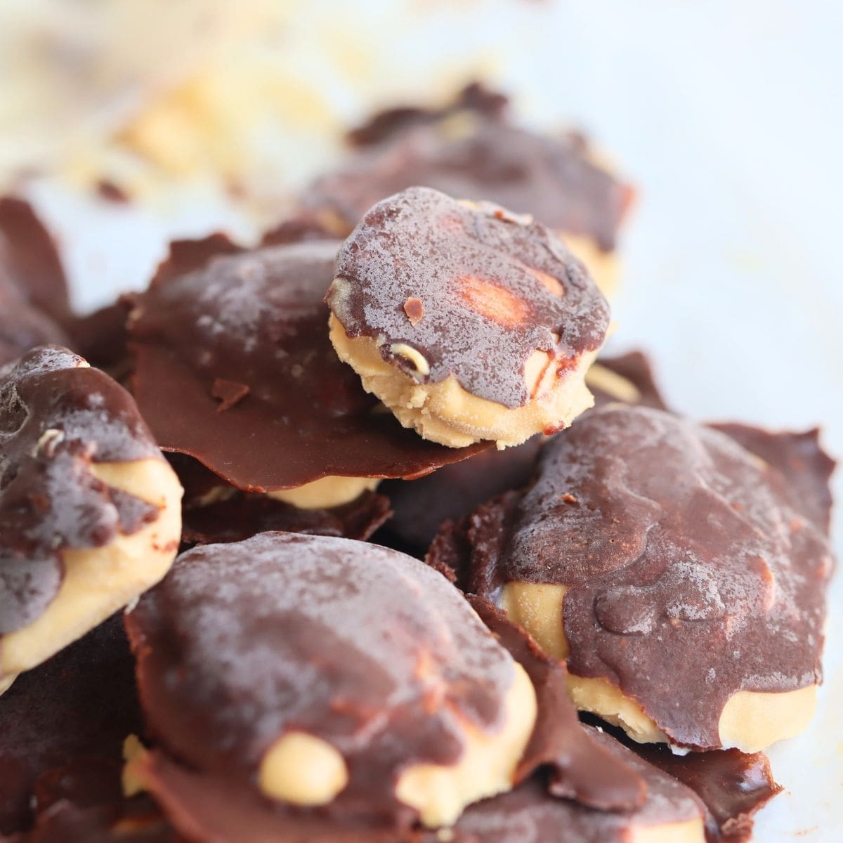 easy frozen Greek yogurt bites (peanut butter and chocolate) in a pile on a white background