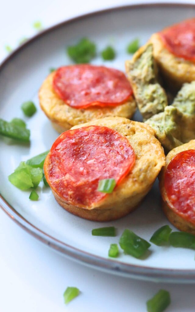 high protein mini pizza muffins on a plate with chopped green onion