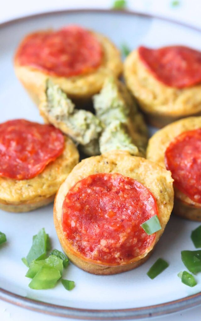 high protein mini pizza muffins on a plate with chopped green onion