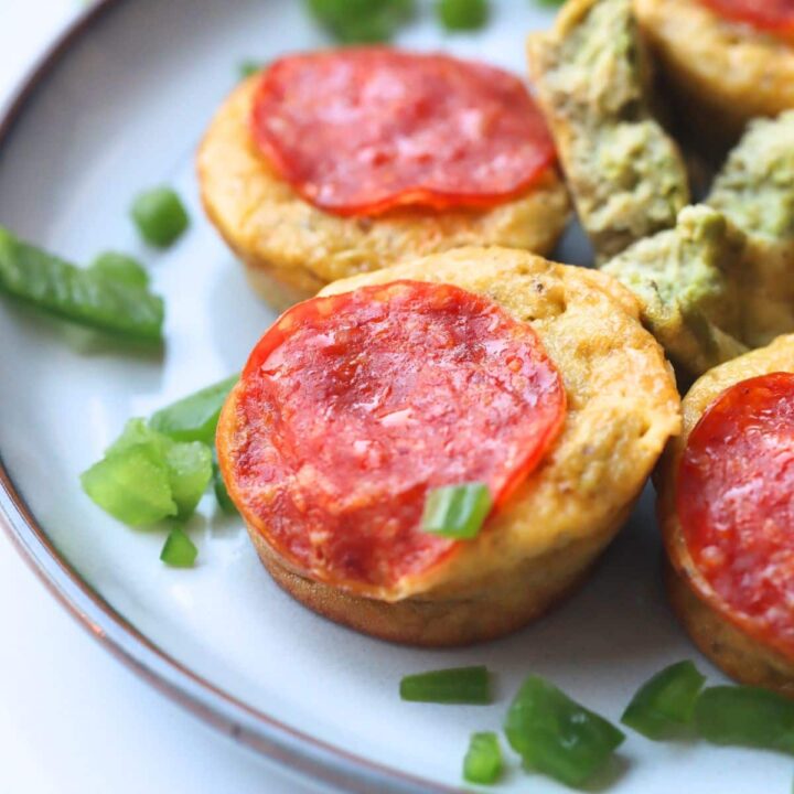 high protein mini pizza muffins on a plate with chopped green onion