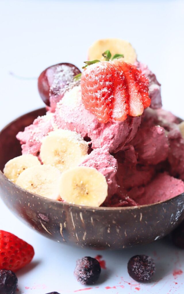 acai ice cream in a coconut wood bowl with mixed berries on top