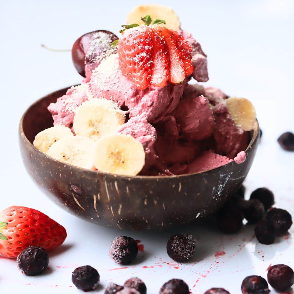 acai ice cream in a coconut wood bowl with strawberries and bananas on top
