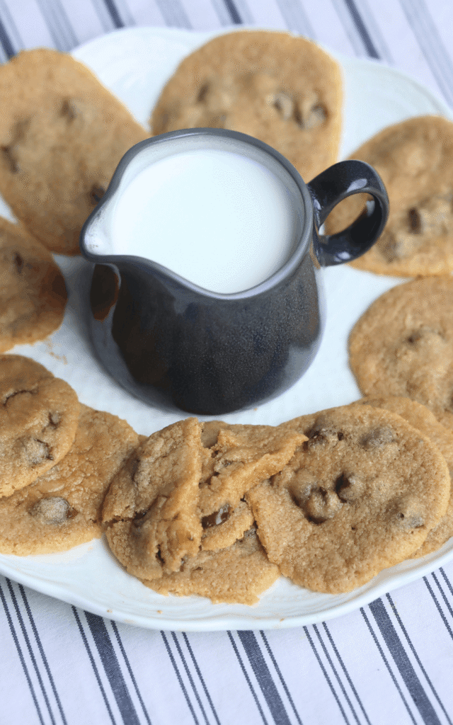 pitcher of milk surrounded by whole wheat chocolate chip cookies