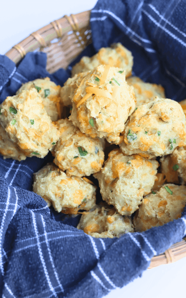 top-down view of homemade cheddar-and-chive biscuits in a basket