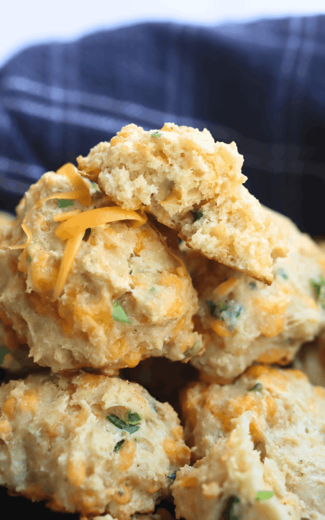 a split biscuit on top of a pile of biscuits in a basket
